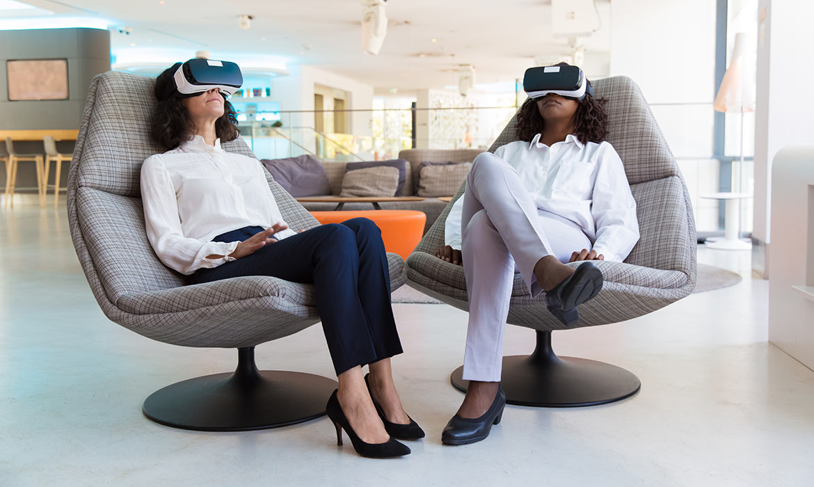 two women sitting in chairs with virtual reality 3D